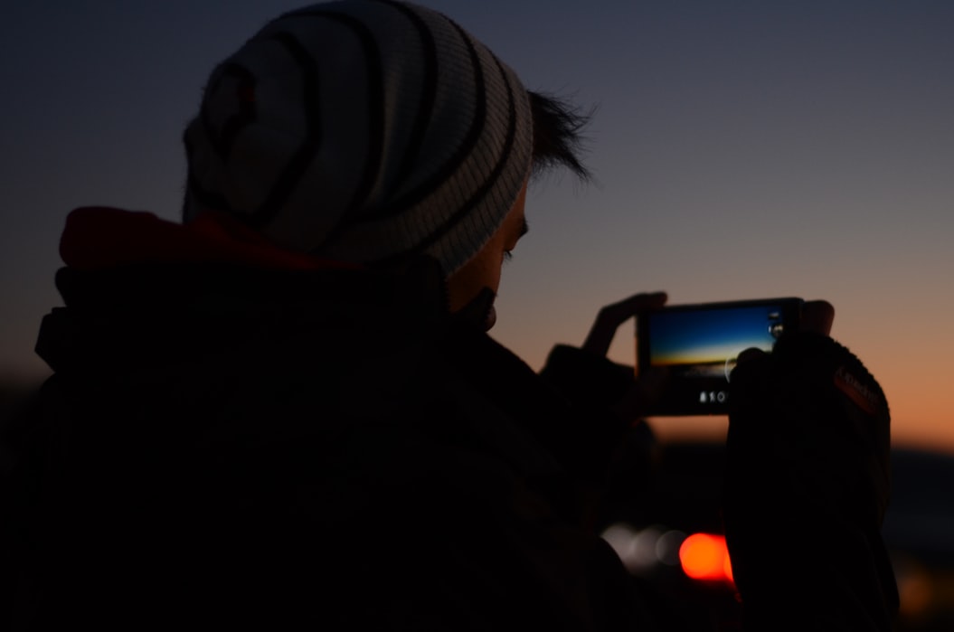 Mężczyzna wykonujący zdjęcie nocne smartfonem